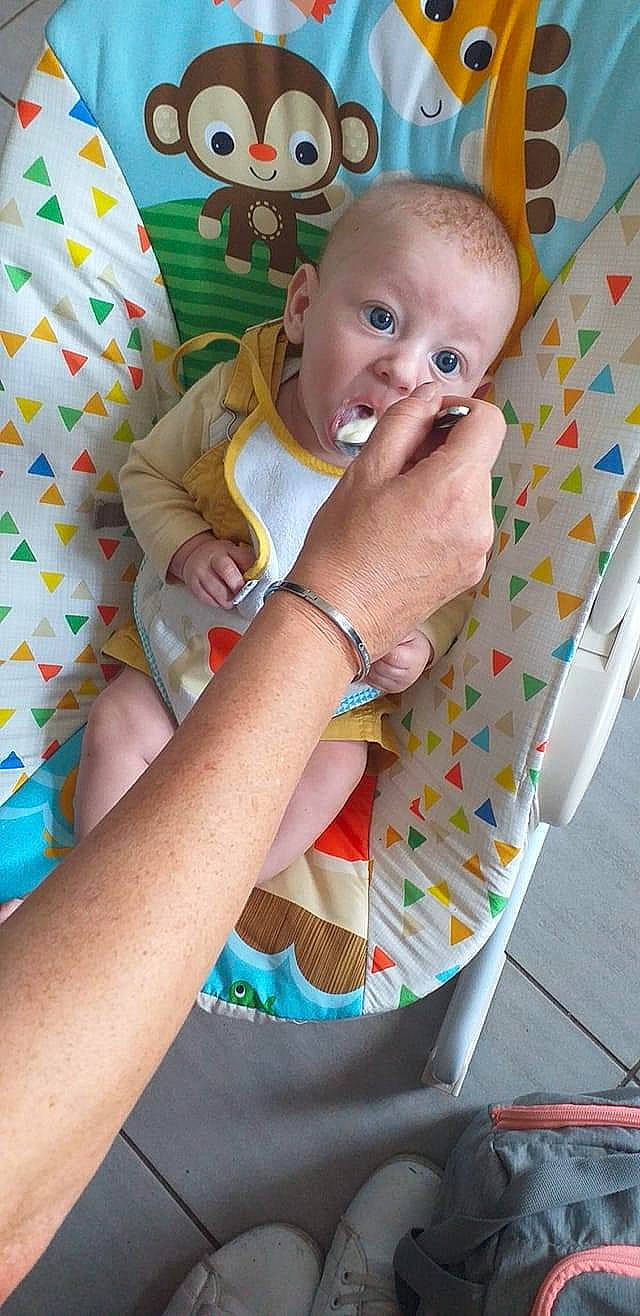 Sacha participe au concours pour gagner de l'argent avec cette photo : arm, baby, baby_products, baby_toddler_clothing, cheek, child, comfort, facial_expression, fun, green, happy, head, iris, linens, pattern, person, product, sitting, skin, surprise