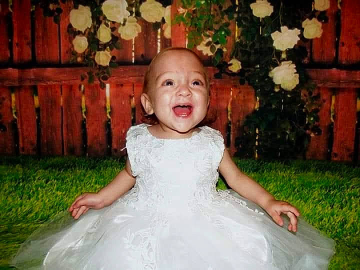 Alena participe au concours pour gagner de l'argent avec cette photo : baby, baby_toddler_clothing, bridal_clothing, dress, eye, flash_photography, flower, hair, happy, head, iris, leaf, lighting, mammal, people_in_nature, person, pink, plant, skin, smile