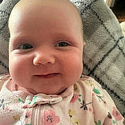 Iris joined the competition — help win amazing prizes! baby, infant, smiling, face, close-up, onesie, floral_pattern, blanket, soft_texture, indoor, cute, child, young, portrait, happy, skin, head, eyes, person, cozy