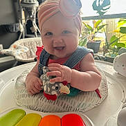 Iris joined the competition — help win amazing prizes! baby, baby_activity_center, cheerful, child, colorful_piano_keys, cute, denim_overalls, furniture, happy, headband, indoor, infant, pacifier, person, plants, playtime, plush_toy, smiling, toy, window