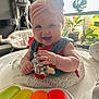 Iris joined the competition — help win amazing prizes! baby, baby_walker, cheerful, child, clothing, colorful, cute, face, furniture, happy, headband, home, indoor, infant, person, plant, plush_toy, sitting, smiling, toy