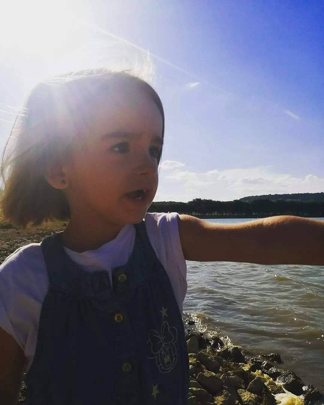 Lylou participe au concours pour gagner de l'argent avec cette photo : beach, child, cloud, flash_photography, fun, gesture, grass, happy, horizon, iris, lake, ocean, person, sky, sleeve, smile, sunlight, t_shirt, toddler, travel