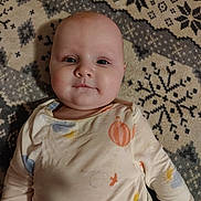 Novalee joined the competition — help win amazing prizes! baby, infant, child, face, cheeks, eyes, onesie, long_sleeves, lying_down, blanket, patterned_blanket, snowflake_pattern, indoor, portrait, close_up, soft_lighting, pink_bag, cozy, calm, smiling