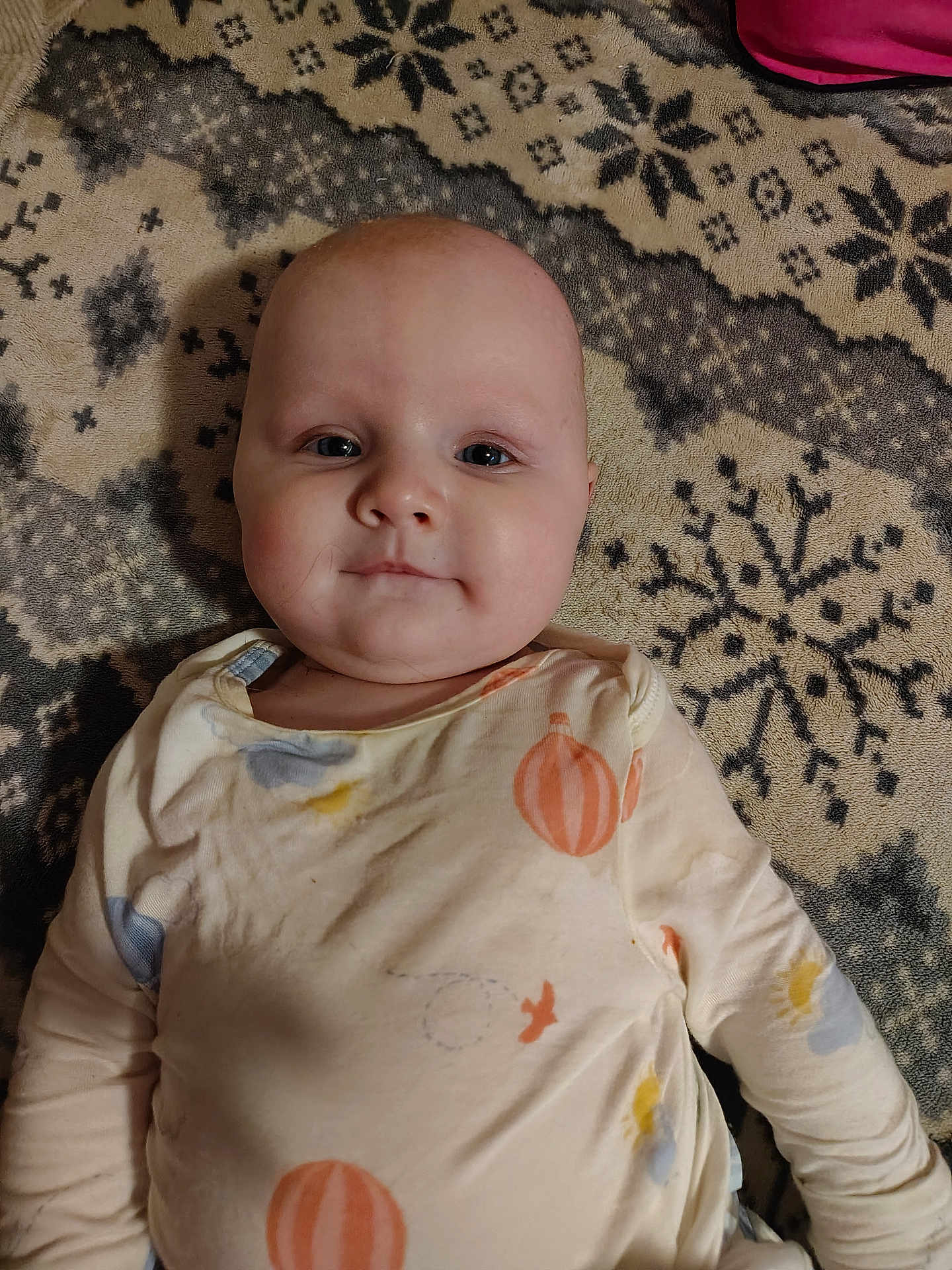 Novalee joined the competition — help win amazing prizes! baby, infant, child, face, cheeks, eyes, onesie, long_sleeves, lying_down, blanket, patterned_blanket, snowflake_pattern, indoor, portrait, close_up, soft_lighting, pink_bag, cozy, calm, smiling