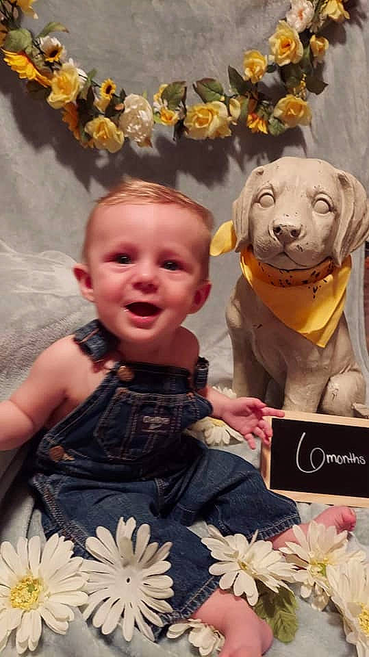 Owen is registered to the contest to win money with this photo: baby_toddler_clothing, beauty, facial_expression, fashion, fun, green, happy, head, organ, person, petal, photograph, pink, smile, snapshot, textile, toddler, vertebrate, white, working_animal