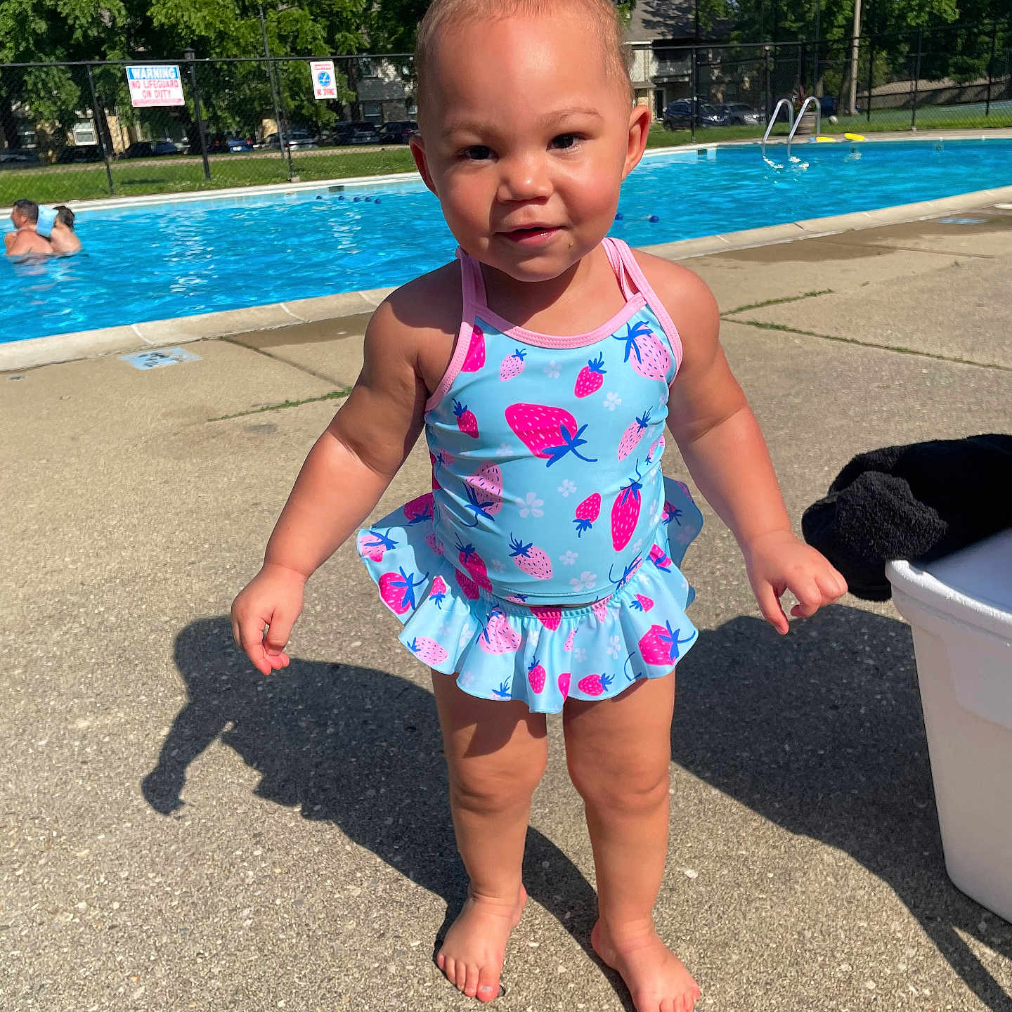 Camyla joined the competition — help win amazing prizes! barefoot, blue, child, concrete, daytime, fence, outdoor, person, pink, playtime, poolside, shadow, smile, summer, sunlight, swimsuit, toddler, trees, water, young_child