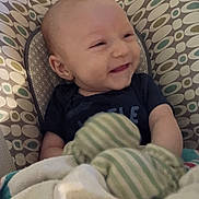 Jackson joined the competition — help win amazing prizes! baby, infant, smile, blanket, mittens, baby_seat, pattern, clothing, cute, happy, child, portrait, indoor, comfort, soft, young, person, face, cozy, rest