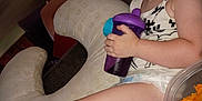 Jameson is registered to the contest to win money with this photo: toddler, child, sippy_cup, couch, nursing_pillow, chips, container, indoor, smile, happy, hair, diaper, clothing, person, furniture, living_room, snack, relaxing, home, portrait