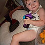 toddler, child, sippy_cup, couch, nursing_pillow, chips, container, indoor, smile, happy, hair, diaper, clothing, person, furniture, living_room, snack, relaxing, home, portrait