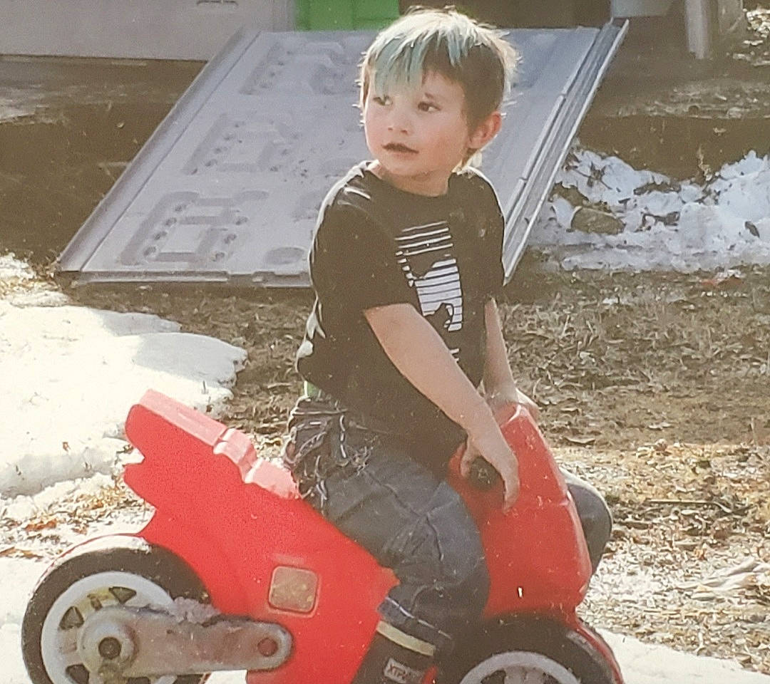 Brody is registered to the contest to win money with this photo: auto_part, automotive_design, automotive_tire, automotive_wheel_system, carmine, child, fender, fun, grass, motor_vehicle, person, riding_toy, rolling, sitting, synthetic_rubber, tire, toddler, toy_vehicle, tread, vehicle