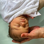 April a rejoint le concours — aidez-le/la à gagner de superbes lots ! newborn, baby, infant, wrapped, white_cloth, hand, cradling, bath, water, peaceful, sleeping, skin, portrait, closeup, tender, care, soft_light, human, baby_face, newborn_baby