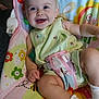 Ella joined the competition — help win amazing prizes! baby, child, smiling, happy, infant, cute, sitting, clothing, dress, socks, face, eyes, furniture, colorful, pattern, indoor, baby_chair, toy, skin, person