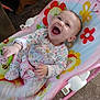 baby, infant, smiling, laughing, baby_bouncer, colorful, floral_onesie, indoor, carpet, toy, child, cute, happy, seat, person, playful, home, cheerful, young_child, baby_toy
