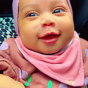 Eleana a rejoint le concours — aidez-le/la à gagner de superbes lots ! baby, child, smiling, headband, pink, bow, pacifier, clothing, bib, cute, portrait, infant, happy, face, hand, patterned_background, indoors, closeup, soft_lighting, holding