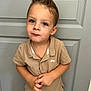 child, boy, portrait, indoor, spiky_hair, blue_eyes, beige_shirt, polo_shirt, gold_necklace, hands, door, casual_clothing, cute, young_child, standing, expression, looking_up, skin, face, person
