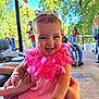 Millie joined the competition — help win amazing prizes! baby, child, smiling, pink_dress, flower_lei, bracelet, outdoor, porch, hand, people, greenery, sunlight, happy, infant, person, family, casual, daylight, celebration, fun