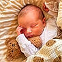 newborn, baby, sleeping, teddy_bear, blanket, cozy, soft, cute, infant, child, bed, comfort, snuggling, warm, face, hand, clothing, portrait, peaceful, resting