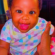 Amoura joined the competition — help win amazing prizes! baby, infant, smiling, happy, child, face, hand, clothing, colorful, diaper, cute, skin, person, portrait, indoors, babywear, expression, sitting, young_child, joy