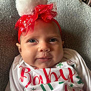 Ella joined the competition — help win amazing prizes! baby, infant, headband, pom_pom, red, white, smiling, face, closeup, holiday, christmas, festive, clothing, text, cute, soft_texture, portrait, indoor, cozy, happy