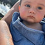 Jesse James is registered to the contest to win money with this photo: arm, baby, blue_towel, cheek, child, close_up, expressionless, eyelashes, face, fence, head, holding, outdoor, person, portrait, skin, sunlight, tattoo, towel, tree