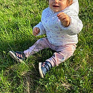Athena a rejoint le concours — aidez-le/la à gagner de superbes lots ! toddler, child, grass, outdoor, jacket, shoes, pants, sitting, nature, greenery, happy, cute, sunlight, sparkles, portrait, young_child, casual_clothing, daytime, smiling, playful