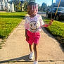 child, girl, sidewalk, peace_sign, braids, beads, pink_skirt, tie_dye_shirt, sneakers, sunny, residential_area, trees, grass, houses, car, jewelry, bracelet, necklace, outdoor, daytime