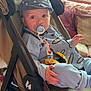 Jacob joined the competition — help win amazing prizes! baby, stroller, pacifier, hat, bib, indoor, child, clothing, person, face, hand, furniture, cushion, blanket, window, light, carpet, footwear, sitting, curious