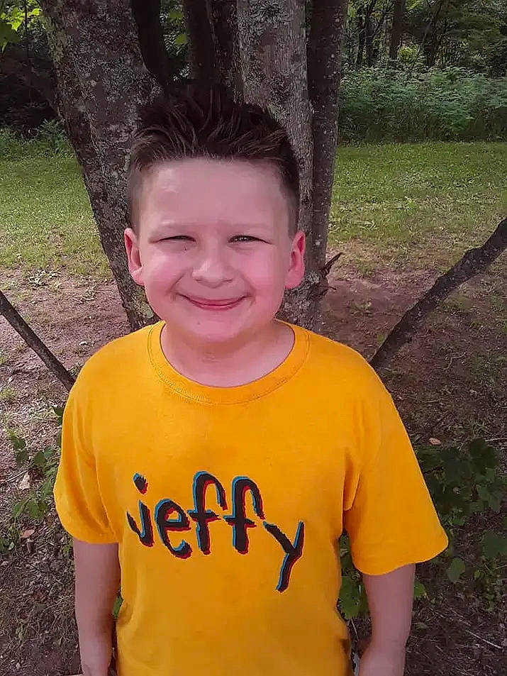 Rocco is registered to the contest to win money with this photo: chin, cool, eye, forehead, grass, hair, hairstyle, happy, head, human_body, joy, lip, mammal, neck, people_in_nature, person, plant, sleeve, smile, t_shirt