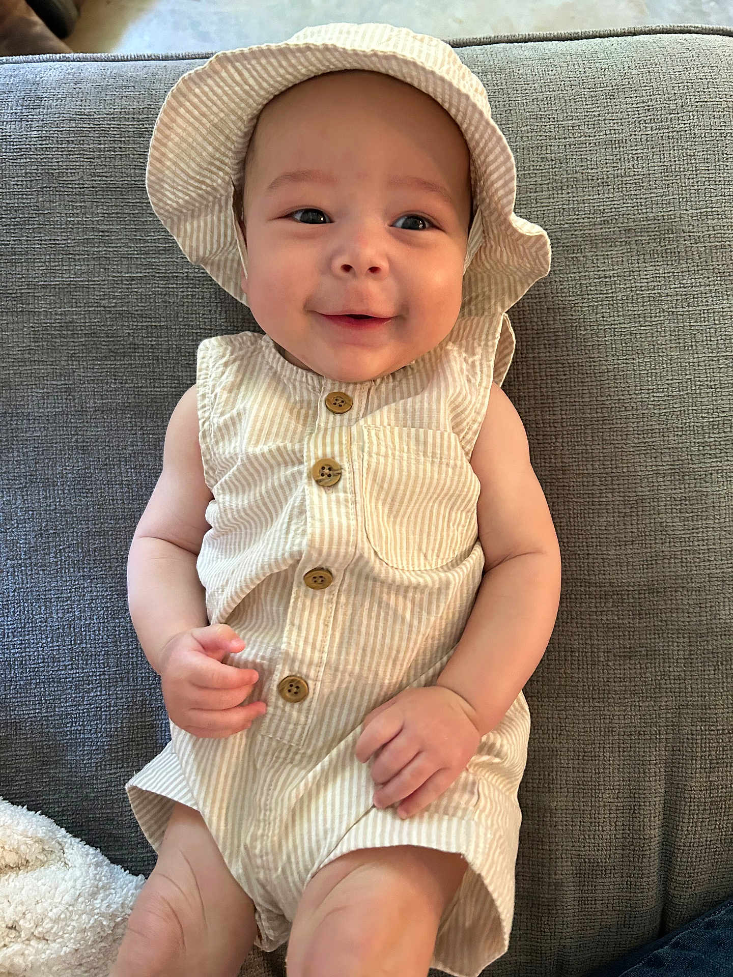 Ldarian is registered to the contest to win money with this photo: baby, infant, smiling, hat, clothing, striped, buttoned, sleeveless, cute, face, person, skin, hand, legs, lying, fabric, texture, happy, child, indoors