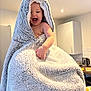 Marnie-Grace is registered to the contest to win money with this photo: baby, blanket, child, indoor, kitchen, laughing, happy, smiling, person, soft_texture, wrapped, cozy, home, cabinet, counter, light, appliance, cute, skin, infant