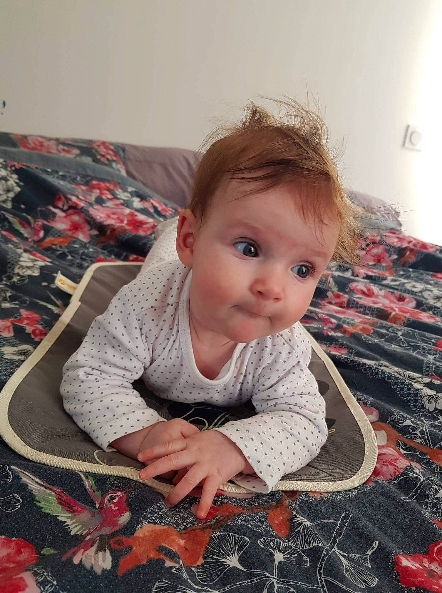 Emma participe au concours pour gagner de l'argent avec cette photo : baby, baby_toddler_clothing, carpet, cheek, child, dress, floor, flooring, fun, iris, linens, pattern, person, play, product, sitting, skin, sleeve, surprise, t_shirt