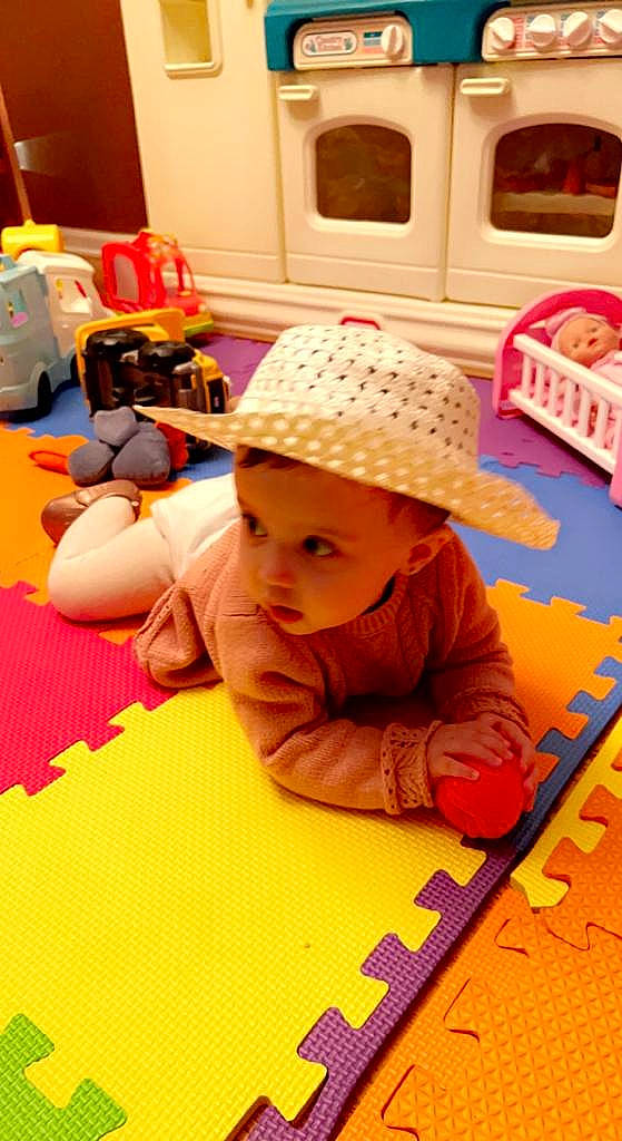 Kayla joined the competition — help win amazing prizes! baby, cap, child, floor, flooring, fun, hat, headwear, kitchen_appliance, learning, leisure, luggage_and_bags, orange, person, play, product, recreation, room, sitting, toddler