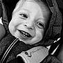 child, toddler, smile, face, teeth, jacket, hood, black_and_white, closeup, happy, eyes, cozy, fabric, baby, portrait, cute, warm, young_child, seatbelt, car_seat