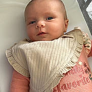 Willow joined the competition — help win amazing prizes! baby, infant, face, bib, clothing, pink, beige, mesh, crib, playpen, cute, child, portrait, lying_down, skin, head, eyes, young, soft, indoors