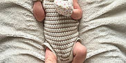 Willow is registered to the contest to win money with this photo: baby, newborn, infant, blanket, headband, mittens, knitted, romper, lying_down, soft_texture, cute, small_feet, small_hands, portrait, indoors, cozy, sleepwear, neutral_colors, closeup, child