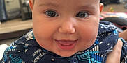 Rebecca joined the competition — help win amazing prizes! baby, child, smiling, indoor, face, person, clothing, pattern, hanukkah, menorah, celebration, happy, cute, portrait, hand, furniture, television, home, buttoned_shirt, infant