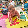 Rebecca joined the competition — help win amazing prizes! baby, child, play_mat, toy, colorful, indoor, floor, books, pink_clothing, smiling, face, hand, developmental_toys, soft_toys, flooring, activity_center, octopus_toy, educational_toys, infant, crawling