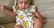 Rebecca is registered to the contest to win money with this photo: baby, beige, blanket, child, chubby, comfortable, couch, cozy, cute, flower_pattern, headband, indoors, infant, pear_pattern, portrait, relaxed, romper, sitting, sofa, soft