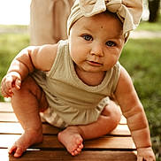 Aryanna joined the competition — help win amazing prizes! baby, child, infant, headband, bow, wood, bench, outdoor, nature, grass, greenery, skin, cute, portrait, sitting, summer, daylight, young, person, closeup