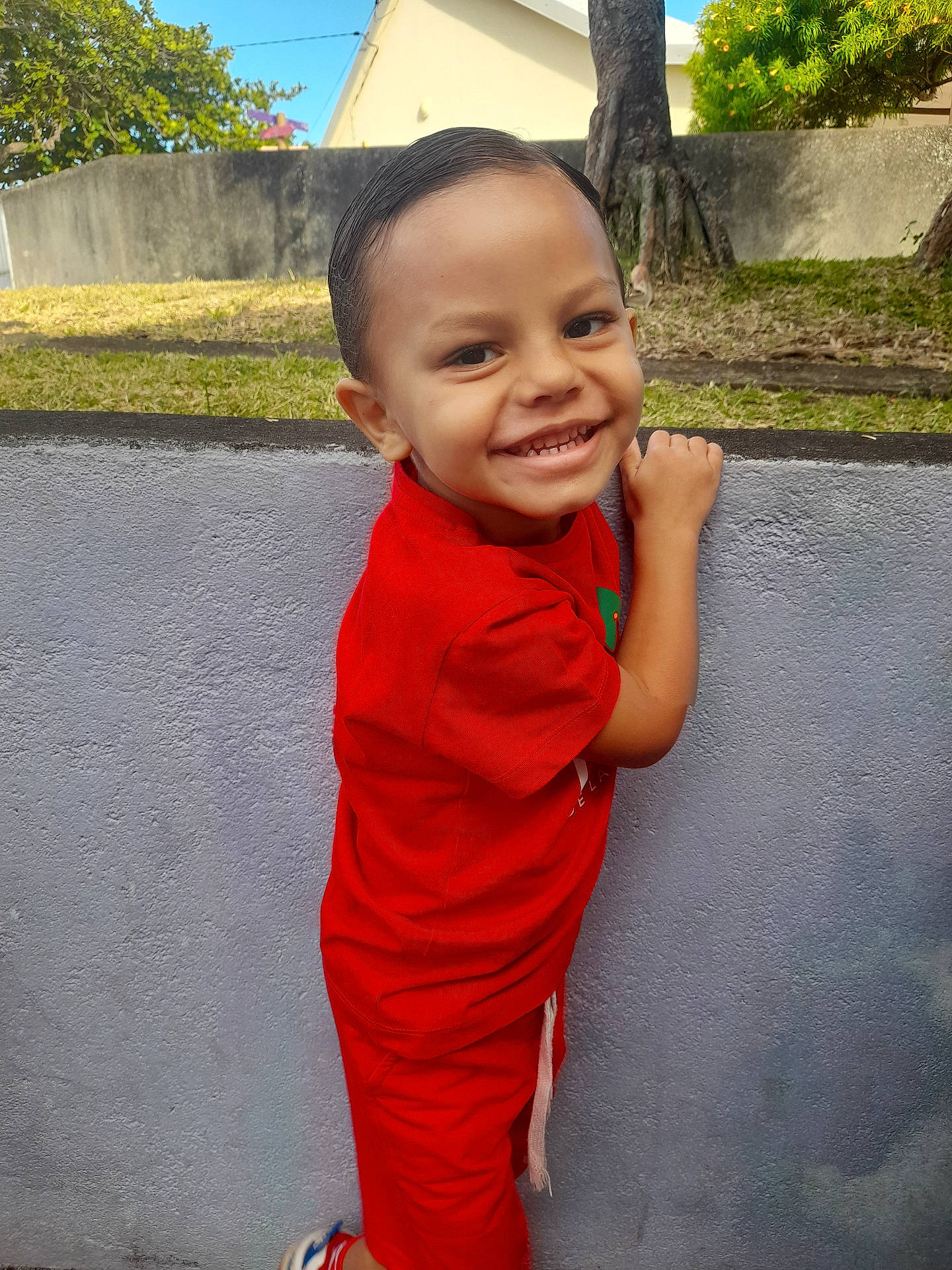 Enzo participe au concours pour gagner de l'argent avec cette photo : architecture, boy, building, child, clothing, dress, face, formalwear, grass, happy, head, male, pants, person, photography, plant, portrait, smile, tree, wall