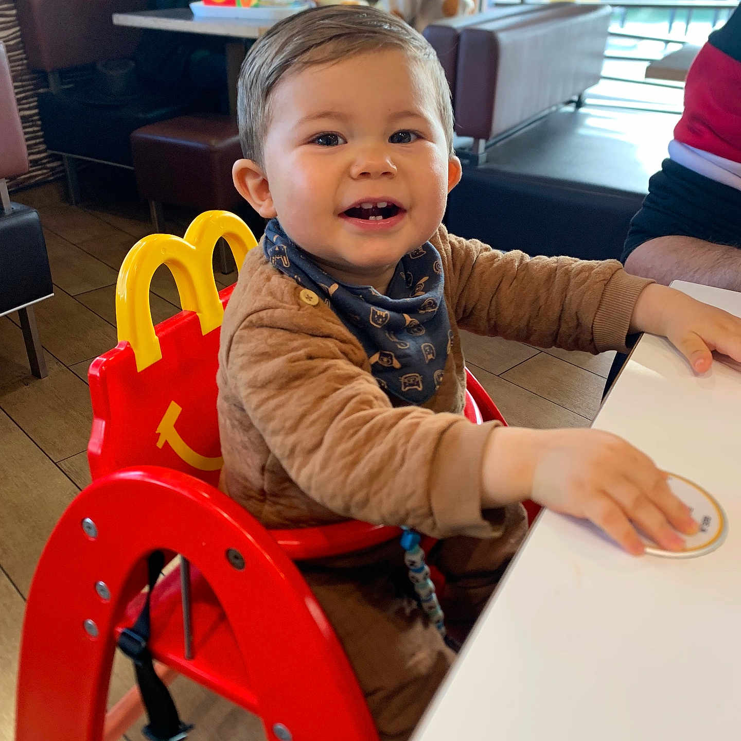 Maylon a rejoint le concours — aidez-le/la à gagner de superbes lots ! baby, brown_clothing, child, coaster, face, fast_food, happy, high_chair, indoor, mcdonalds, people, person, red_chair, restaurant, scarf, seat, smiling, table, toddler, wood_floor