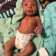 Amir joined the competition — help win amazing prizes! baby, infant, diaper, towel, blanket, smile, face, skin, hand, foot, newborn, cute, lying_down, soft_texture, cozy, happy, child, indoors, portrait, resting
