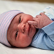 Kayce is registered to the contest to win money with this photo: baby, blue, child, closeup, clothing, cute, expression, face, hand, hat, infant, lying_down, newborn, newborn_baby, person, pink, portrait, skin, sleepwear, soft