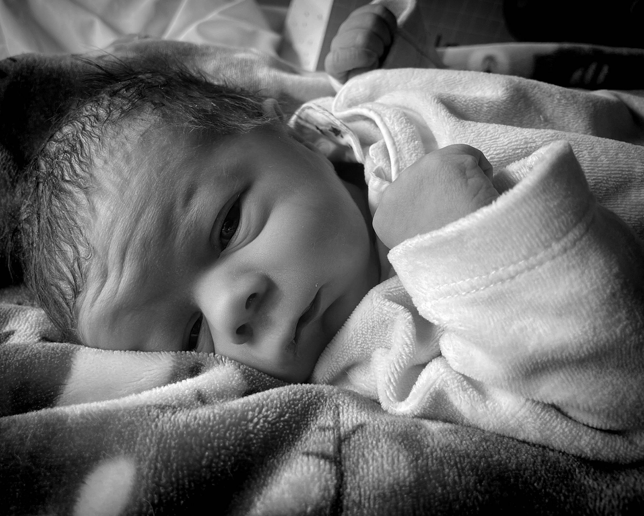 élio participe au concours pour gagner de l'argent avec cette photo : baby, black_and_white, cheek, child, comfort, eye, eyebrow, face, flash_photography, happy, head, iris, linens, monochrome, monochrome_photography, nose, person, skin, textile, toddler