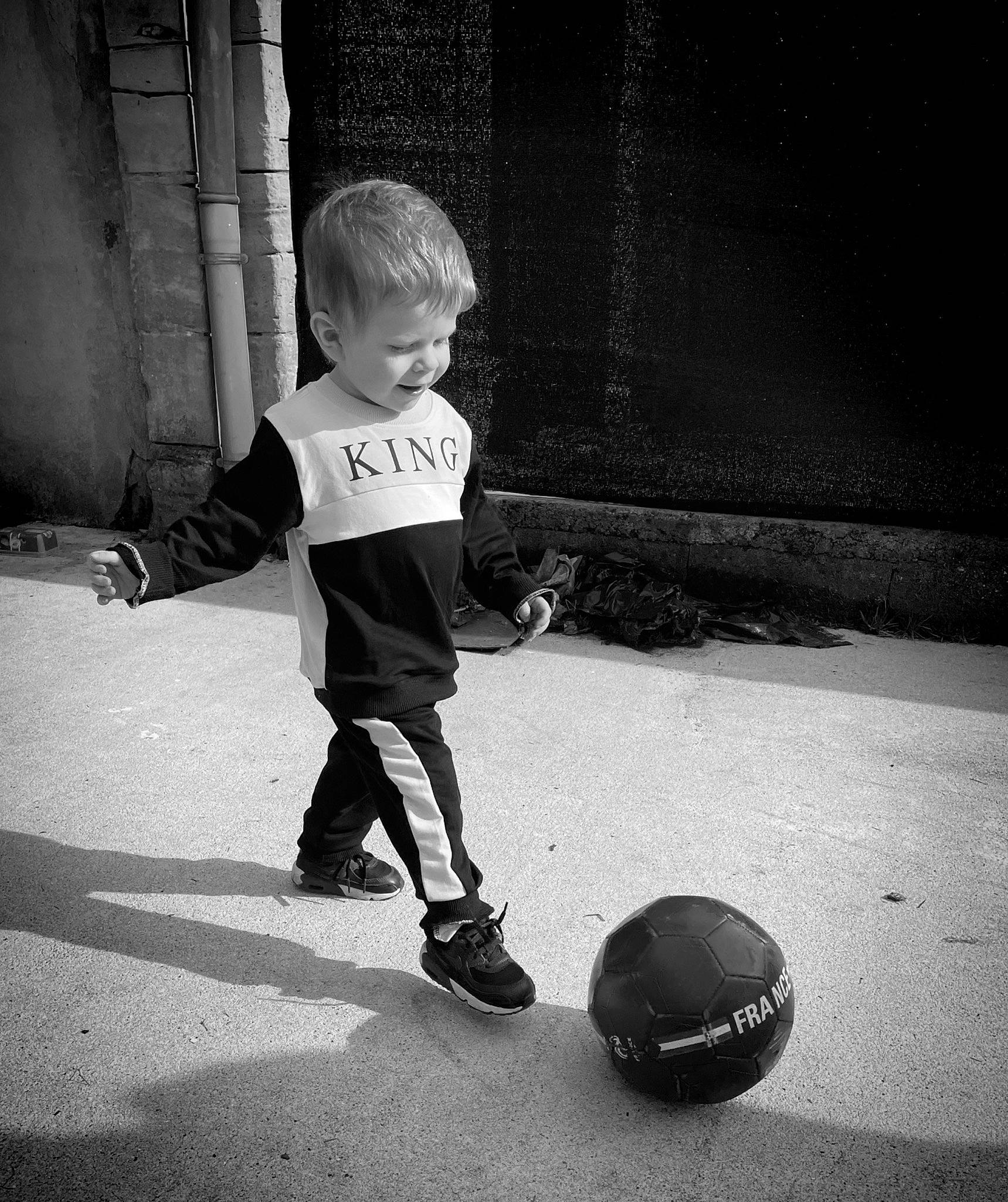 Naël participe au concours pour gagner de l'argent avec cette photo : asphalt, ball, black, black_and_white, flash_photography, fun, happy, leg, monochrome, monochrome_photography, person, player, recreation, road, sports, sports_equipment, standing, street, style, tints_and_shades