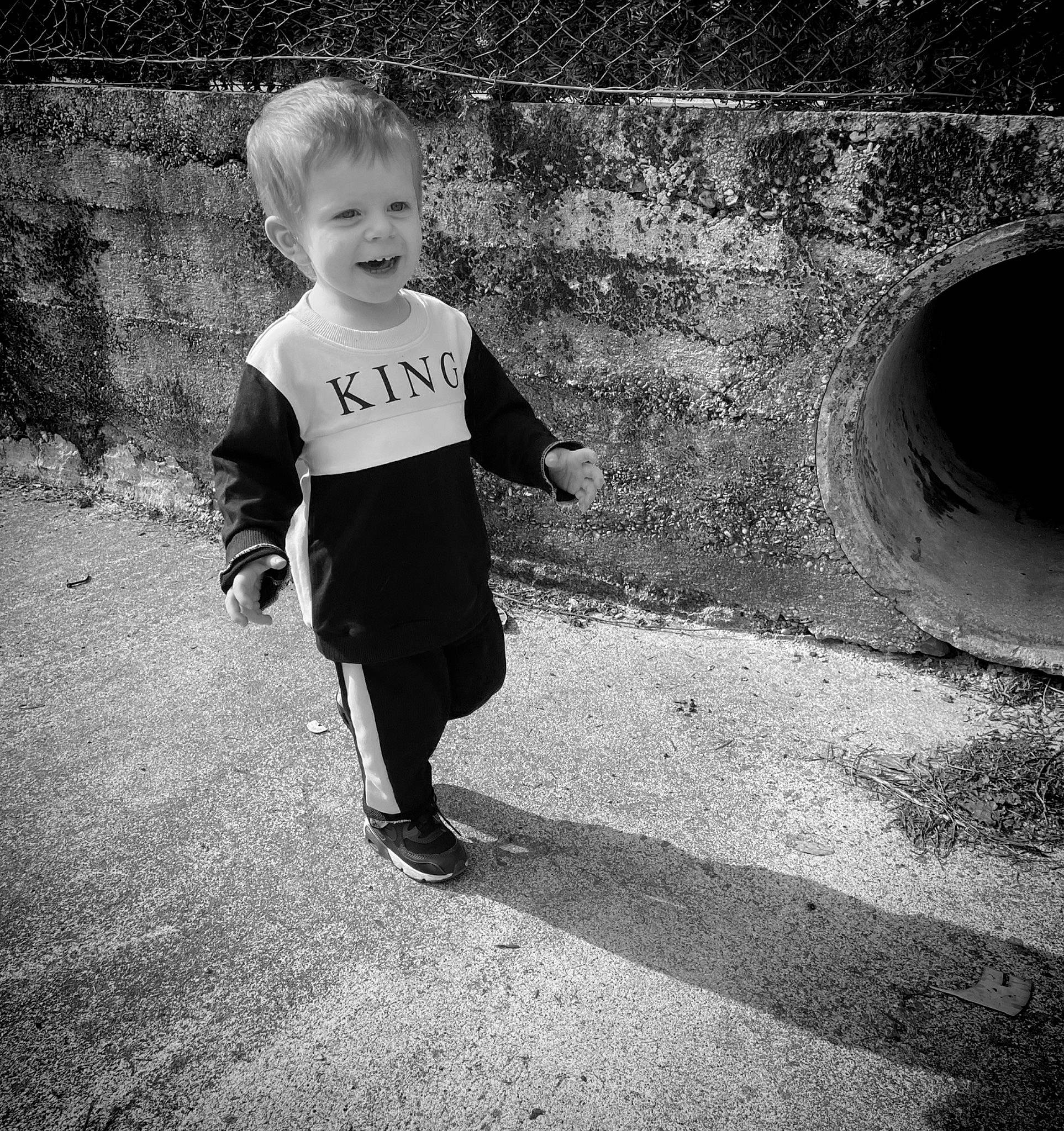 Naël participe au concours pour gagner de l'argent avec cette photo : art, asphalt, black_and_white, child, flash_photography, gesture, grass, happy, monochrome, monochrome_photography, people_in_nature, person, road, road_surface, sidewalk, standing, style, t_shirt, tints_and_shades, toddler