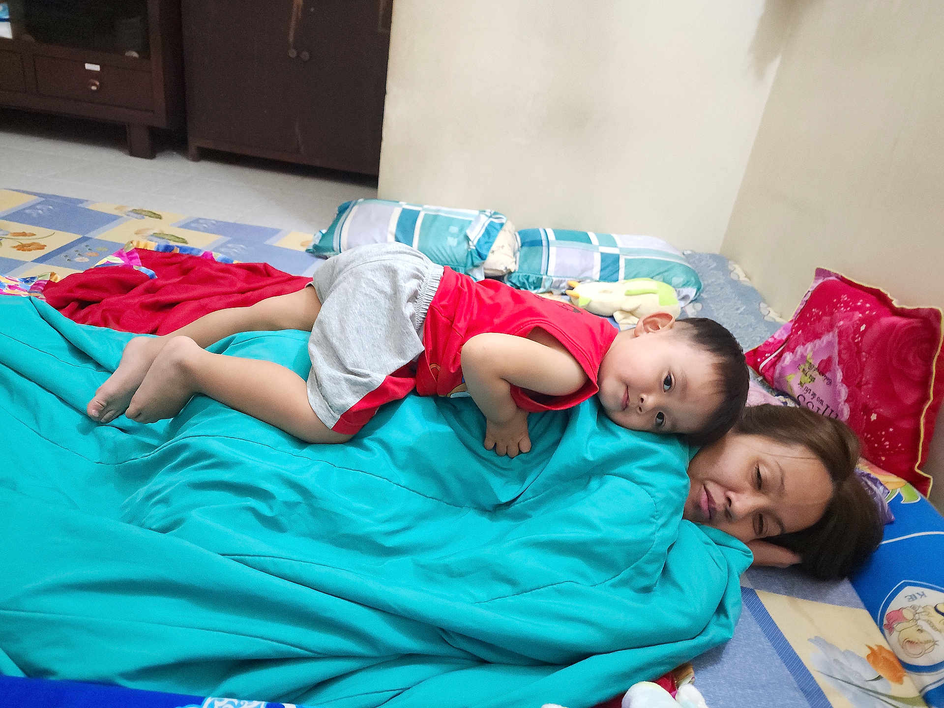 Ryu Le Nguyen joined the competition — help win amazing prizes! toddler, woman, blanket, pillow, indoor, child, resting, floor, cushion, bedroom, sleeping, red_shirt, gray_shorts, toy, home, casual, portrait, family, relaxation, comfort