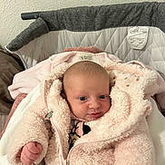Yelena participe au concours pour gagner de l'argent avec cette photo : baby, infant, pink_jacket, fluffy_clothing, bassinet, blanket, pacifier, indoor, cute, face, newborn, child, person, warm, soft_texture, sleepwear, head, eyes, hand, cozy