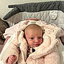 baby, infant, pink_jacket, fluffy_clothing, bassinet, blanket, pacifier, indoor, cute, face, newborn, child, person, warm, soft_texture, sleepwear, head, eyes, hand, cozy