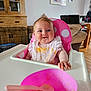 Bethany is registered to the contest to win money with this photo: baby, high_chair, bib, food, messy, smiling, face, pink, polka_dot, bowl, spoon, indoor, living_room, wooden_furniture, photographs, child, cute, feeding, happy, person